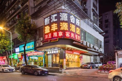 a building with neon signs on the side of it at Ying Feng Yuan Hotel in Guangzhou