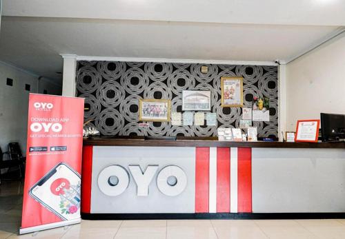 OYO 2400 Maleo Exclusive Residence في باندونغ: متجر أويا مع علامة أمام منضدة