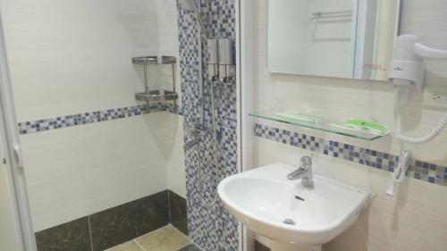 een badkamer met een wastafel en een douche bij 7街160民宿 in Jian