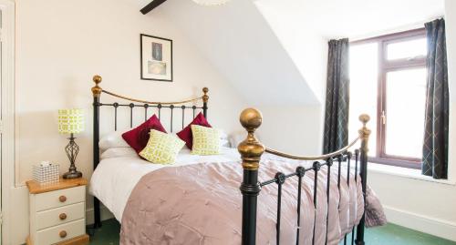 a bedroom with a bed with red and yellow pillows at Rooms by Maes y mor Town Centre in Aberystwyth