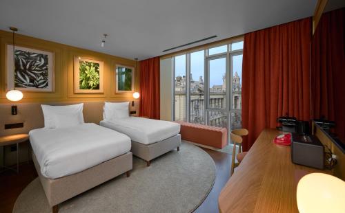 a hotel room with two beds and a television at Verno House in Budapest