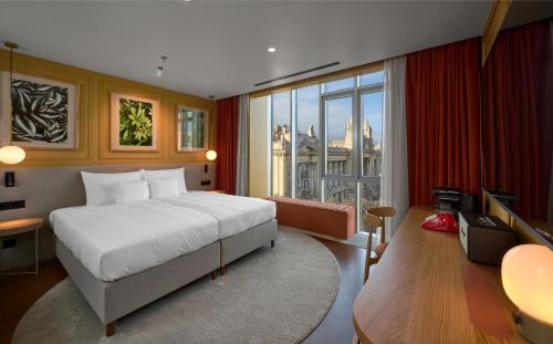 a bedroom with a large bed and a large window at Verno House Budapest, Vignette Collection by IHG in Budapest