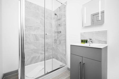 een badkamer met een douche en een wastafel bij New Apartment in Brierley Hill - Parking - Wifi - Netflix - Top Rated - 309O in Birmingham