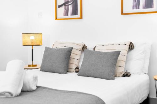 a white bed with four pillows and a lamp at New Apartment in Brierley Hill - Parking - Wifi - Netflix - Top Rated - 309O in Birmingham