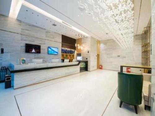 a lobby with a waiting area with a green chair at City Comfort Inn Hotel Changchun Puyang Street FAW Automotive Trade City in Changchun
