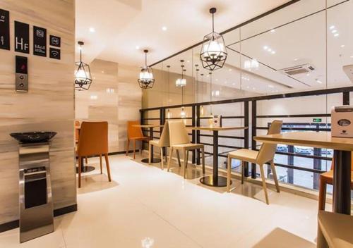 Dianbailiao的住宿－City Comfort Inn Beihai Yintan International Ferry Terminal，一间带桌椅的餐厅以及一个阳台