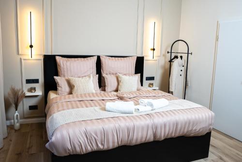 ein Schlafzimmer mit einem großen Bett mit zwei Handtüchern darauf in der Unterkunft Angelinas Service Apartment 4 in Oberhausen