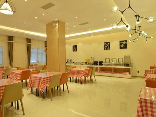 LedongにあるCity Comfort Inn Ledong Bus Stationのテーブルと椅子、カウンター付きのレストラン