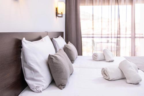 a bedroom with two beds with white pillows and a window at RVHotels GR92 in Torroella de Montgrí