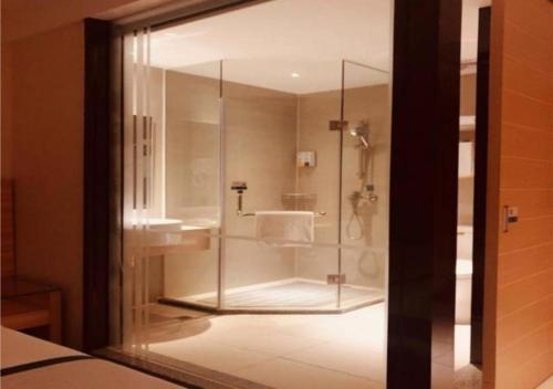 uma casa de banho com uma cabina de duche em vidro e um lavatório. em City Comfort Inn Zhuhai Jinwan Hangkong Xincheng em Baigaonongchang