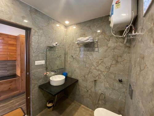 uma casa de banho com um chuveiro, um lavatório e um WC. em The Aesthetic Hotel & Restaurant em Bhīm Tāl