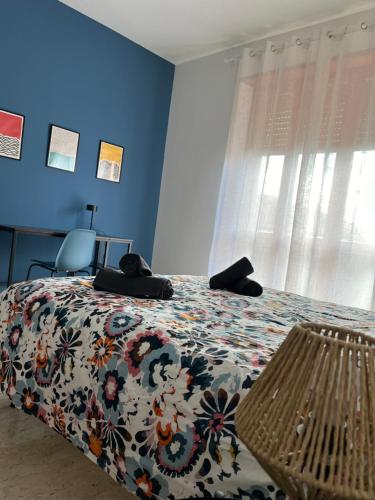 a bedroom with a bed with a floral bedspread and a window at Casa Marconi - City Center in Bra