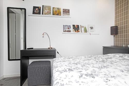 a bedroom with a bed and a dresser and a mirror at Villastadens Pendlarbostad in Gävle