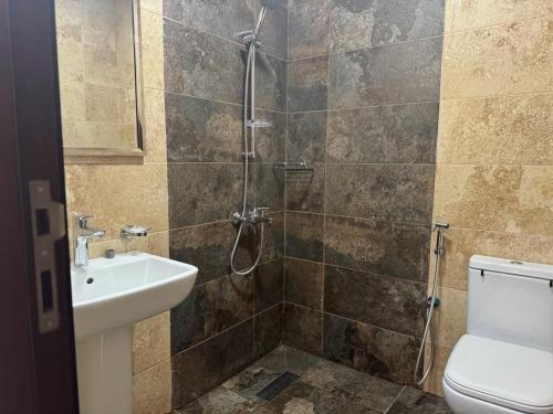 a bathroom with a shower and a toilet and a sink at Star building in Khor Fakkan