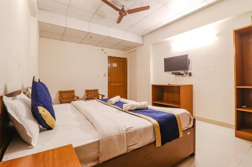 a bedroom with a large bed and a flat screen tv at Hotel PARAS TOWER in Dehradun