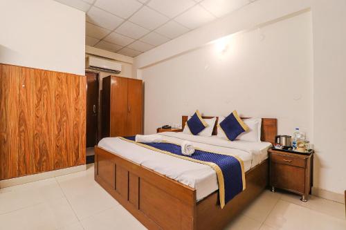 een slaapkamer met een groot bed met blauwe kussens bij Hotel PARAS TOWER in Dehradun