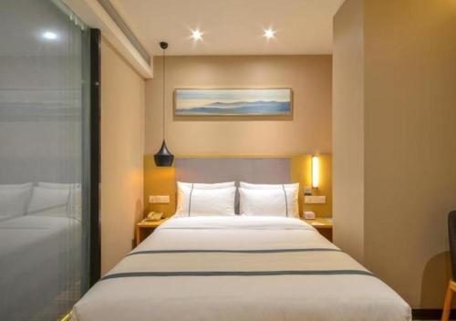 - une chambre avec un grand lit blanc dans l'établissement City Comfort Inn Jingzhou Hongxing Road Food Street, à Pu-ho