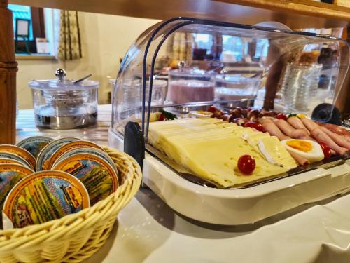 a buffet with a plate of food and a basket of food at Zum Franziskaner in Grainau