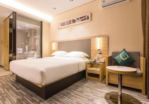 a hotel room with a large bed and a bathroom at City Comfort Inn Wuzhou Arcade City Sanzongfu in Wuzhou