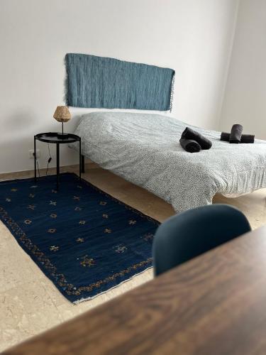 a bedroom with a bed with a blue rug and a table at Casa Marconi - City Center in Bra
