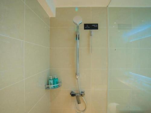 a shower with a shower head in a bathroom at City Comfort Inn Hechi Tian'E Bus Terminal 
