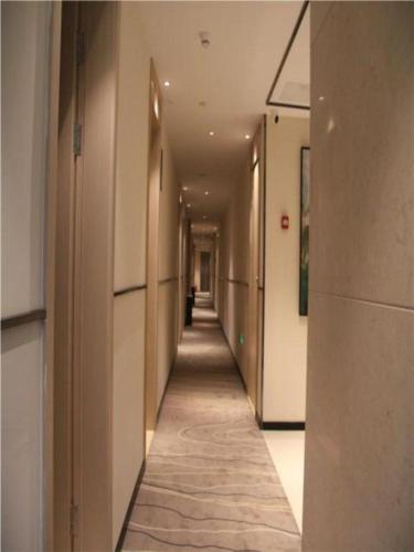 um corredor de um edifício de escritórios com um longo corredor em City Comfort Inn Kaifeng Xiaosongcheng Qingming Shangheyuan em Kaifeng