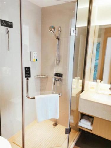 a bathroom with a glass shower and a sink at City Comfort Inn Kaifeng Xiaosongcheng Qingming Shangheyuan in Kaifeng