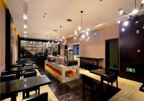 a restaurant with tables and chairs and a fireplace at City Comfort Inn Wuhan Guanggu Finance Port in Liufangling