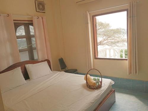 - une chambre avec un lit et un panier dans l'établissement KhopChai Guesthouse, à Houei Sai