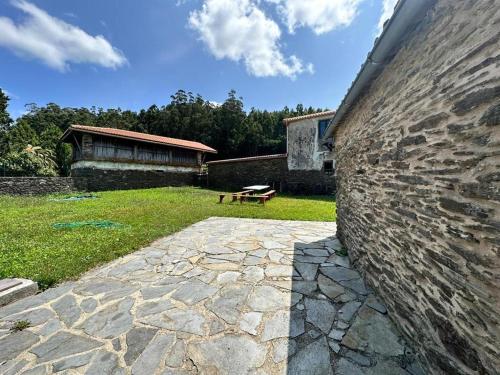 a stone wall with a bench in a yard at Casal de Pedra in Santa Irene