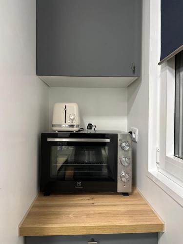 - un four micro-ondes installé sur un comptoir dans la cuisine dans l'établissement Lacharriere-Logement entier 38m2, à Paris