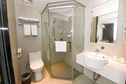 a bathroom with a shower and a toilet and a sink at City Comfort Inn Zhenjiang Dashikou Suning Plaza in Zhenjiang