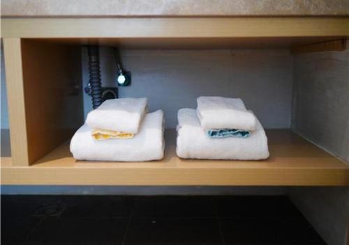 three towels sitting on a shelf in a bathroom at City Comfort Inn Maoming Donghuicheng Cultural Plaza in Maoming