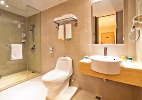 a bathroom with a toilet and a sink and a shower at City Comfort Inn Zhuhai Hengqin Ocean Kingdom Huafa Shangdu in Nanping