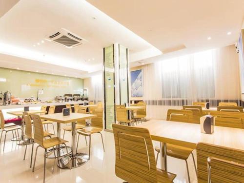 un restaurante con mesas y sillas y una cafetería en City Comfort Inn Nanning Wuming Xiangshan Avenue en Wuming