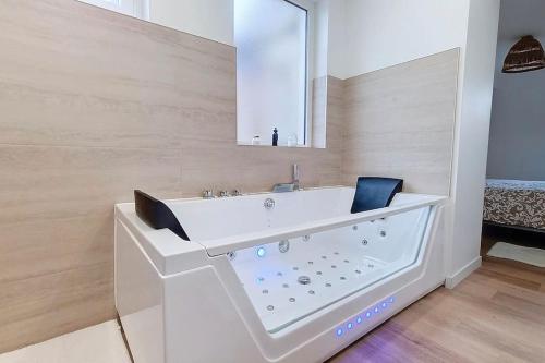 une salle de bain blanche avec un lavabo et un miroir dans l'établissement La drapière - Maison centre ville, à Louviers