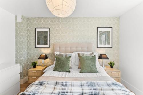a bedroom with a bed with two lamps and two mirrors at The Augustine - Stylish City Centre Gem in Kent
