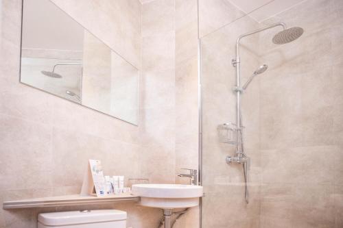 a bathroom with a shower and a toilet and a sink at RVHotels GR92 in Torroella de Montgrí