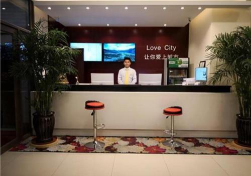 City Comfort Inn Changchun Jida First Hospital Xi Minzhu Street في تشانغتشون: رجل يقف في عداد متجر مدينة الحب