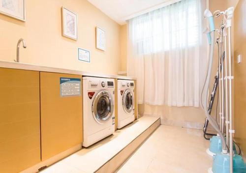 a laundry room with a washer and dryer next to a window at City Comfort Inn Changchun Jida First Hospital Xi Minzhu Street in Changchun
