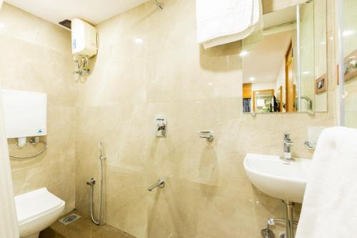 a bathroom with a sink and a toilet at Hotel Village Residency in Mumbai