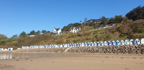 a row of colorful beach huts on a hill at LE CHALET in Saint-Pierre-dʼArthéglise