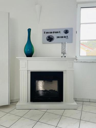a fireplace with a vase sitting on top of it at Haus Rehlein in Pleiskirchen