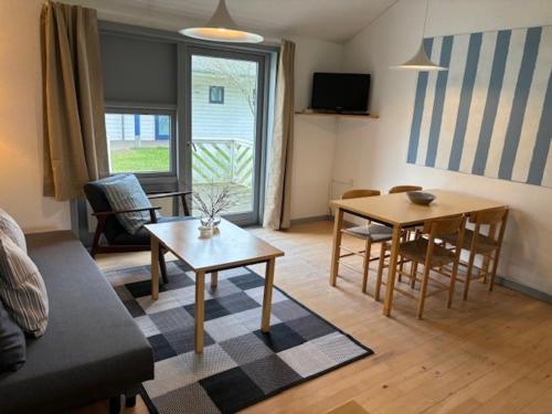 齊斯維勒萊厄的住宿－Sankt Helene Feriecenter Tisvildeleje，客厅配有沙发和桌子