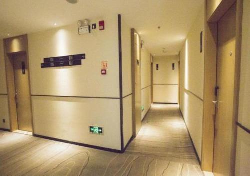 an empty hallway with a refrigerator in a building at City Comfort Inn Luchuan Hot Spring Plaza High-speed Railway Station 