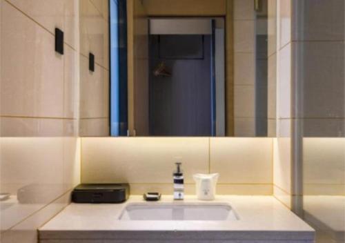 a bathroom with a sink and a mirror at City Comfort Inn Jiaxing Tongxiang Tongxing Avenue in Tongxiang