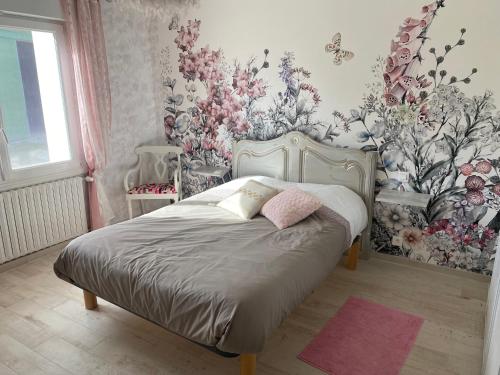 Schlafzimmer mit einem Bett mit Blumentapete in der Unterkunft Maison 3ch soullans in Soullans