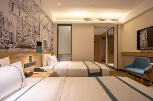 um quarto de hotel com duas camas e uma cadeira azul em City Comfort Inn Shenyang Olympic Sports Center Wanda Plaza em Shenyang