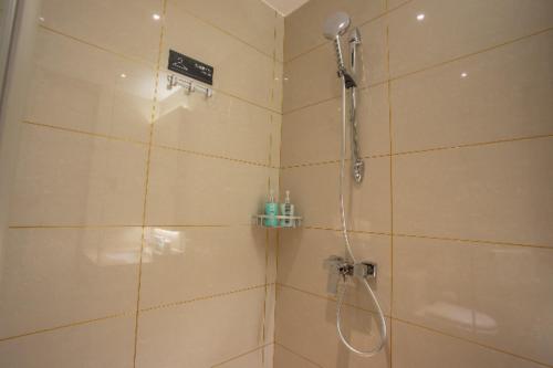 uma casa de banho com chuveiro e cabeça de chuveiro em City Comfort Inn Shenyang Olympic Sports Center Wanda Plaza em Shenyang