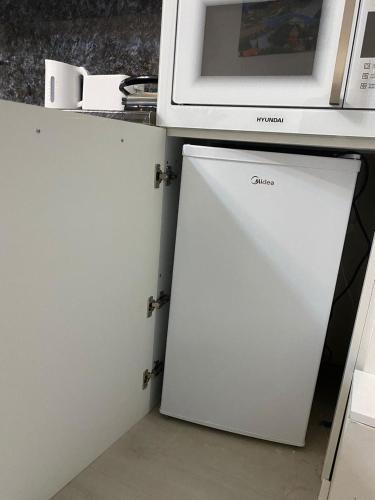a white cabinet with a microwave on top of it at Cultural Crossing Hotel in Tbilisi City